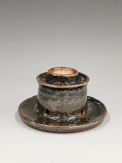 Lidded incense burner on a wide saucer.