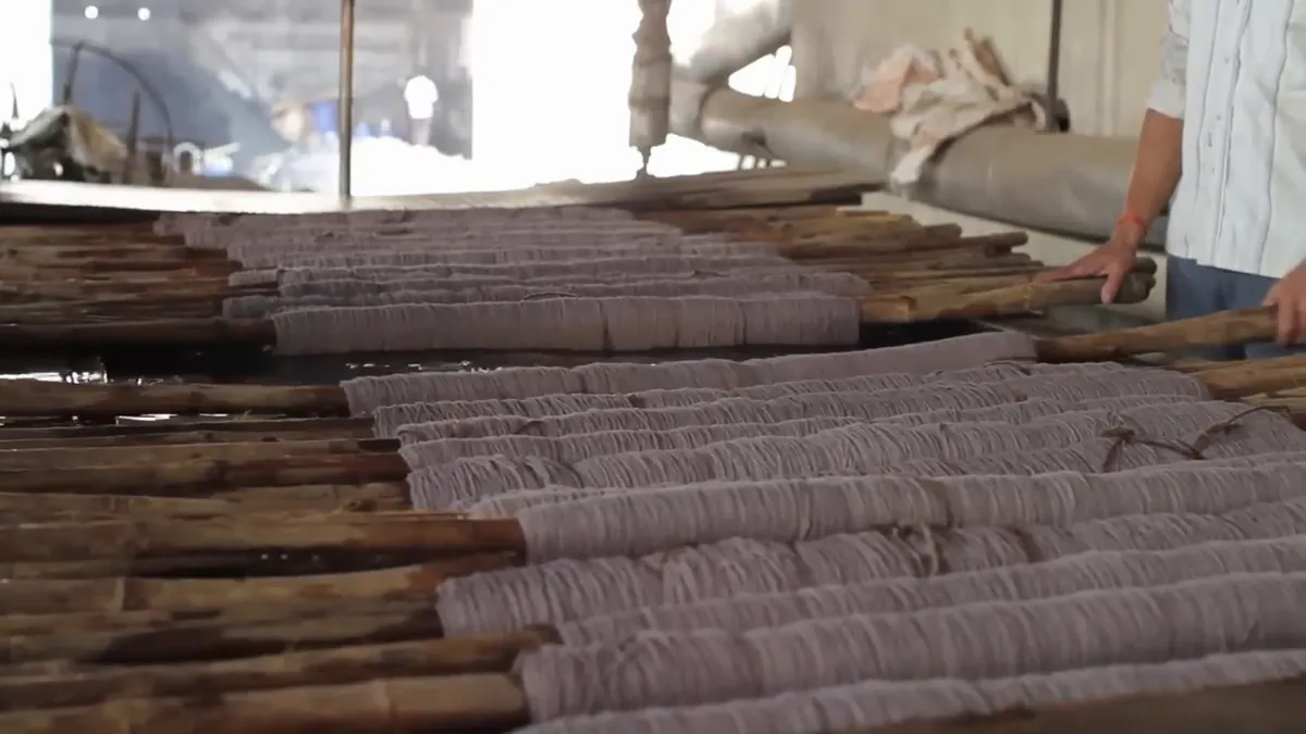 Freshly dyed wool laid over wooden poles to dry.