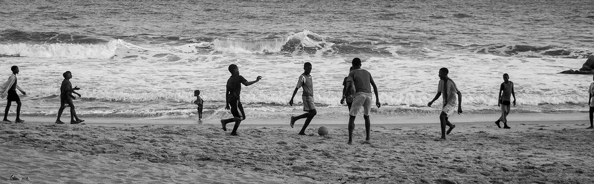 Black and white: boys playing football on the beach at Cape Coast.